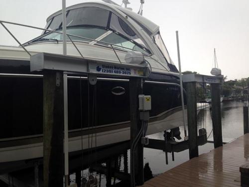 Side view of a white and black boat on a 40,000 pound 4 motor 8 post boat lift.