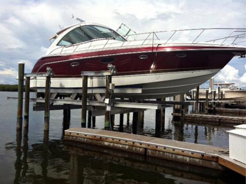 Red and white boat on a 56,000 pound 8 Post Boat Lift installed on Fort Myers Beach.