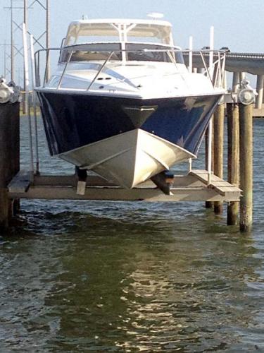 Front view of blue and white boat on an 8 post boat lift in New Jersey.