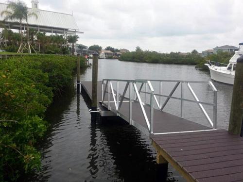 brown walk way leading to matching aluminum floating dock in water 