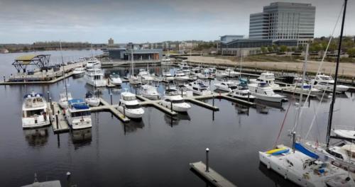 picture of concrete floating dock with many boats parked 