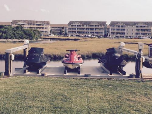 Three multi-colored jet skis on a decked over pwc lift.