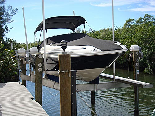 front angled view of white covered boat on gatorvator lift