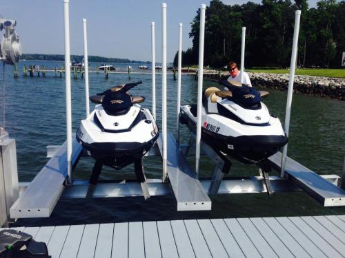 Front view of two white jet skis on a pwc lift with walkways.