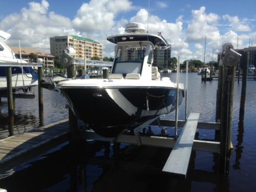 Front view of a black and white boat on a 4 Post Lift