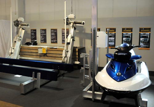 Boat lift and pwc lift holding a blue and white jet ski in a display room.