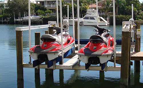 Two red jet skis on a pwc lift.