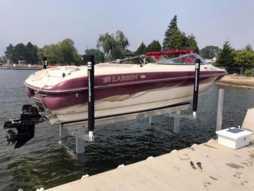 Dock view of a White and Burgandy boat on a Tornado Lift
